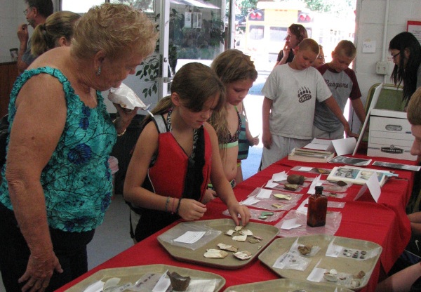 Visitors examine artifacts from the 2013 dig